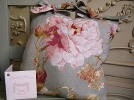 Our Vintage Rose cushion is beautiful.  Made usng the best cuts of fabric.  Each cushion masures 10" x 10" and finished with a dusky pink fabric to the rear and two Vintage Rose ties to the top. Price: &pound;13.54