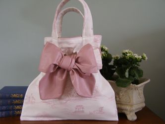 Our French & Floral Pink Toile hand bag is very sweet and made to an extremely high standard. Each bag has a French inner lining, a thick co-ordinating lining and an inside Pink Toile fabric pocket with our own French & Floral label. Every bag has a detachable bow to the front and is finished off perfectly. Our Pink Toile hand bag stands on its own - you will not be disappointed! 
 Price: &pound;34.66