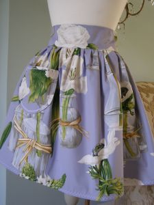 Our Iris & Amaryllis French apron is sumptuous. Made with generous amounts of gather and a deep, high waistband. Every Iris & Amaryllis apron has been made with a large front pocket and a long wide tie to the rear. Finished with fine scalloped edge contrasting stitching. Iris & Amaryllis daughters co-ordinating pinafore dress available).  Fully Machine Washable.
 Price: &pound;37.60
